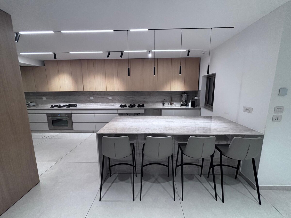 Dekton countertops with wooden upper cabinets and integrated PITT gas burners